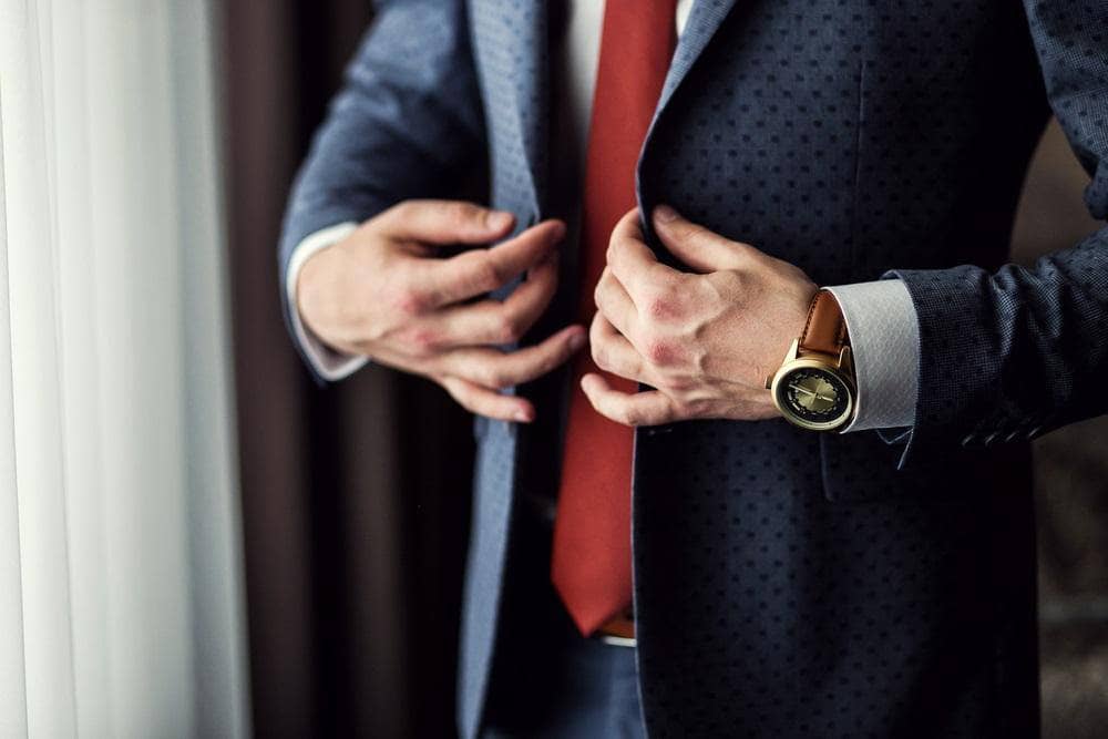 A close up of torso of a man wearing a nicely tailored suit that fits