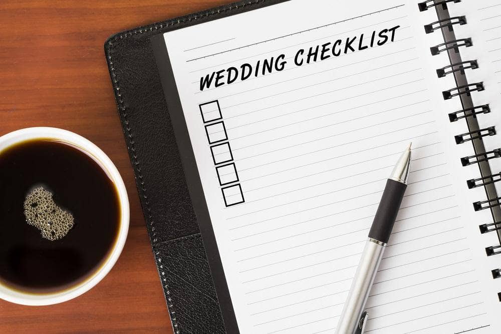 wedding checklist for groom on a notepad with a pen and a cup of coffee
