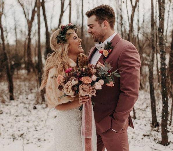 A winter wedding scene of bride and groom in a winter forest