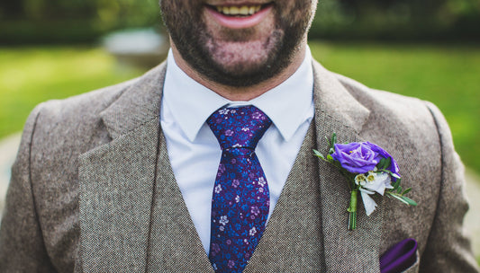 Close up of man wearing grey tweed suits, top of head cut off and chest is visible